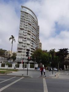 a tall white building with people walking in front of it at Viña Park 2 in Viña del Mar