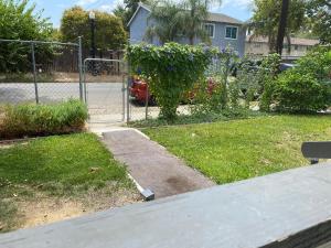 a gate in a yard with a garden with flowers at WHOLE Family - Barrette (front) in Sacramento