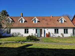 a large white house with a red roof at Wannborga Vingård in Köpingsvik