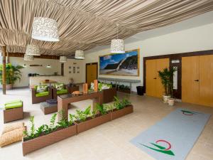 a lobby with a living room with furniture and plants at Rede Andrade Comfort in Natal