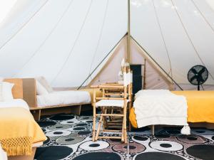 a room with beds and a desk in a tent at The Hideaway Cabarita Beach in Cabarita Beach