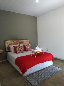 a bedroom with a large bed with a red blanket at Sítio Aroeira Chalés in Sao Jorge