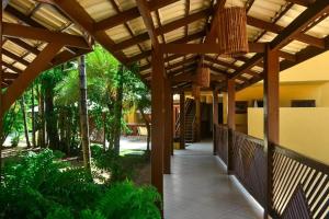 pérgola de madera sobre una pasarela en un edificio en Paz & Diversão Praia Do Forte, en Praia do Forte