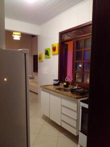 eine Küche mit einer Spüle und einem Kühlschrank in der Unterkunft LAZULLI PRAIA VILLAGE - CONDOMÍNIO PRIVATIVO - Orla Sul- Ilhéus - Bahia in Ilhéus
