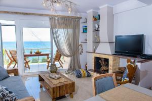 sala de estar con chimenea y vistas al océano en Sul Mare, en Diakopto