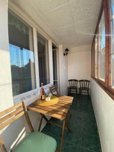 a room with a table and chairs on a balcony at Kék Nefejelcs apartman in Bükkszentkereszt