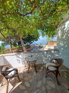a patio with two chairs and a table and a table at Beautiful house located on a hill in Samos Island, 400 m from an organized beach in Koumeika