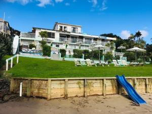 dom z placem zabaw z niebieską zjeżdżalnią w obiekcie San Marino Motor Lodge Absolute Beachfront w mieście Coopers Beach
