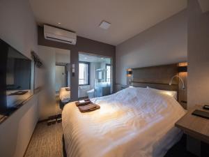 hotel H2 TRIP&BUSINESS NAGASAKI tesisinde bir odada yatak veya yataklar