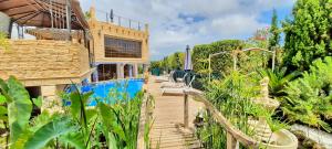 ein Haus mit einem Holzsteg neben einem Pool in der Unterkunft Villa Sun Carlos in Benissa