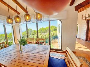 ein Esszimmer mit einem Holztisch und einem Balkon in der Unterkunft Villa Sun Carlos in Benissa