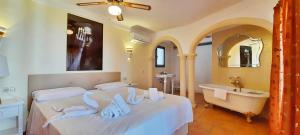ein Schlafzimmer mit einem Bett, einer Badewanne und einem Waschbecken in der Unterkunft Villa Sun Carlos in Benissa