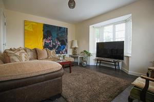a living room with a couch and a flat screen tv at Premium 4 large double bed townhouse in Bicester, next to Bicester Village in Bicester