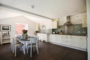 a kitchen with a table and chairs in a kitchen at Premium 4 large double bed townhouse in Bicester, next to Bicester Village in Bicester
