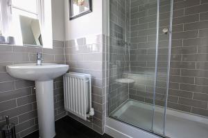 a bathroom with a sink and a shower at Premium 4 large double bed townhouse in Bicester, next to Bicester Village in Bicester +29 photos