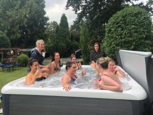 a group of women sitting in a hot tub at Rainbow 3BR flat & luxury Spa option in Bournemouth