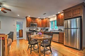 a kitchen with a table and a stainless steel refrigerator at Cape Cod Home with Deck about 3 Miles to Beaches in Bourne