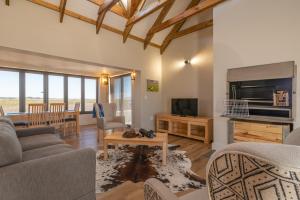 a living room with a couch and a tv at Lermitage Game Lodge - Solar Power in Velddrif