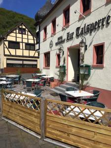 a restaurant with tables and chairs in front of a building at Astoria Hotel Heimbach in Heimbach