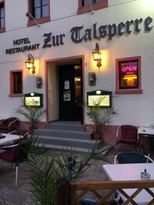 ein Restaurant mit Tischen und Stühlen vor einem Gebäude in der Unterkunft Astoria Hotel Heimbach in Heimbach