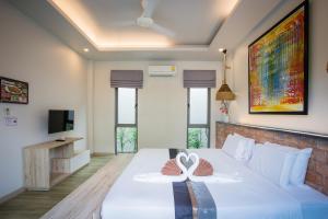 1 Schlafzimmer mit einem großen weißen Bett und 2 Handtüchern in der Unterkunft Yipmunta Pool Villa - SHA Plus Certified in Strand Bang Tao