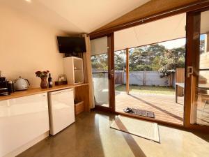 a kitchen with a sliding glass door to a deck at Grape Juice Retreat Rustic romantic gateway 5mins to beaches & town in Margaret River Town