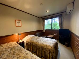 a hotel room with two beds and a window at Petit Hotel Kazekozou in Shinano +103 photos