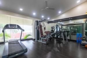 un gimnasio con máquinas de correr y una cinta de correr en StayVista's Emerald Acres offering a heated pool, bonfire, snooker table, scenic views, tennis court, steam room, gazebo, & gym, en Lonavala 44 fotos más