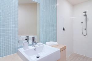a bathroom with a sink, toilet, and shower at 201 Lake Street in Cairns