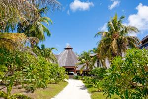 einen Weg, der zu einem Resort mit Palmen führt in der Unterkunft Denis Private Island Seychelles in Denis Island