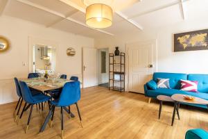 sala de estar con mesa y sofá azul en Le 22-GregIMMO-Appart'Hôtel en Montbéliard