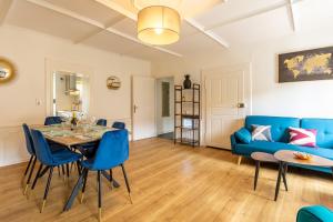 a living room with a table and a blue couch at Le 22-GregIMMO-Appart'Hôtel in Montbéliard