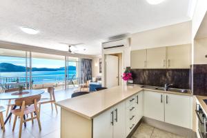 a kitchen and dining room with a view of the ocean at Whitsunday East 1106 on Hamilton Island by HamoRent in Hamilton Island
