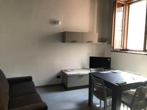 Appartamento Gloria في كريمونا: غرفة معيشة صغيرة مع طاولة وأريكة