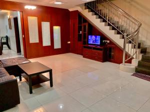 un salon avec un escalier et une télévision dans l'établissement Awani Homestay, à Permatang Janggus