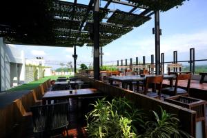 a restaurant with tables and chairs on a roof at Java Heritage Hotel Purwokerto in Purwokerto