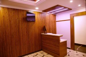 Pokój z drewnianą ścianą z blatem i telewizorem w obiekcie Vismaya Comforts w mieście Mysuru