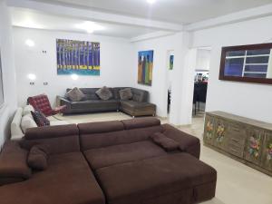 una sala de estar con un sofá marrón en una habitación en Aima Ibagué, en Ibagué