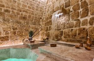 ein Steinzimmer mit einem Brunnen in einer Steinwand in der Unterkunft Dalaa in Akkon