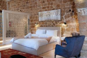 a bedroom with a bed and a blue chair at Dalaa in ‘Akko