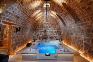 a bath room with a tub in a brick wall at Dalaa in ‘Akko