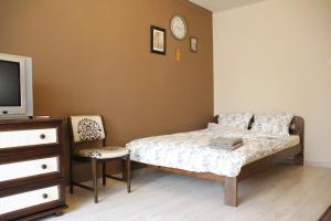 a bedroom with a bed and a tv and a chair at Apartment Widok in Krakow