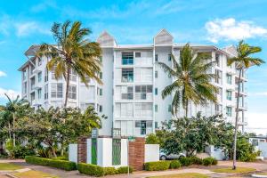 a white building with palm trees in front of it at 201 Lake Street in Cairns