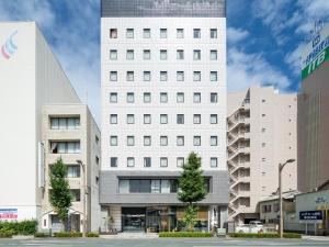 een groot wit gebouw voor sommige gebouwen bij EN HOTEL Hamamatsu in Hamamatsu