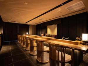 un bar en una habitación con una fila de sillas en One Suite THE GRAND, en Nakijin