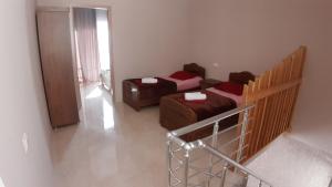 a room with two beds and a balcony with a staircase at Apartment IMERI in Ureki