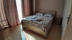 a bedroom with a bed with a zebra print sheets and pillows at Apartment IMERI in Ureki +25 photos