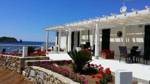 ein Haus mit einer Terrasse voller Blumen und dem Meer in der Unterkunft Le poste di Simplicio B&B in Campese