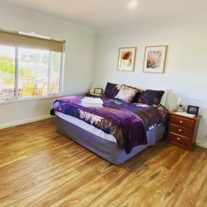 um quarto com uma cama e piso em madeira em The Mains Guest House 2 Bedroom Farm Stay em Corrigin