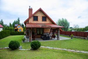 a house with a porch and a patio at Dom gościnny na Mazurach Jędrzejki - rowery,łódka,kajak in Kallinowen